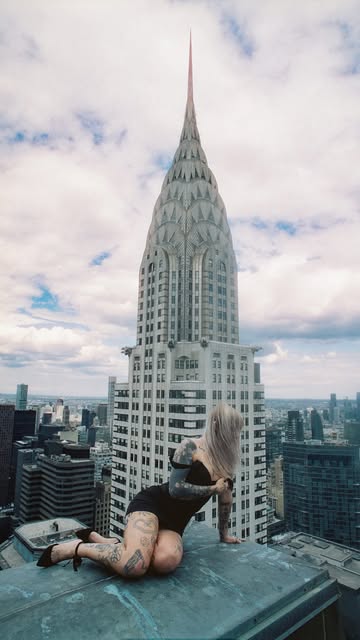 Casper (@caspertheghos7) seated on a Midtown Manhattan ledge with the Chrysler Building spire behind her